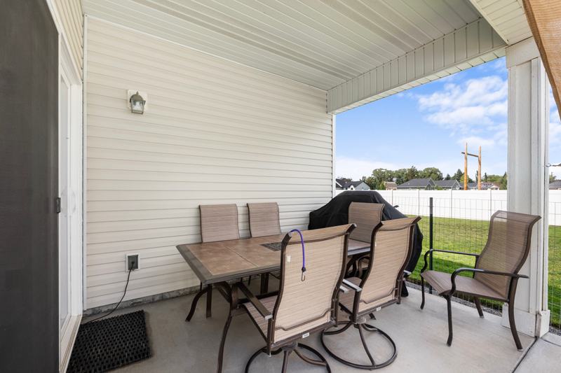 A covered back patio and a large, fenced yard extend the living space outside