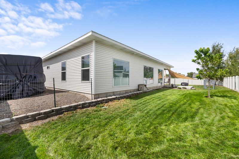 A covered back patio and a large, fenced yard extend the living space outside